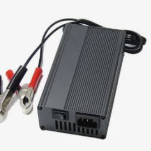 A black rectangular electronic power adapter or inverter with ribbed sides, attached to black cables with red and silver alligator clips, shown on a plain white background.