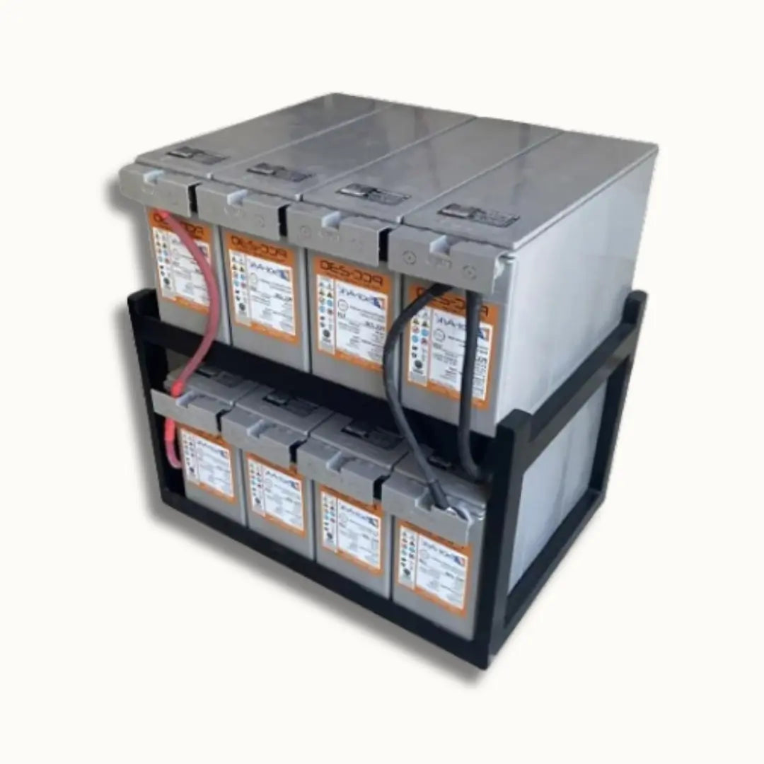 A stack of industrial lead-acid batteries in a black metal rack, photographed on a plain off-white background.