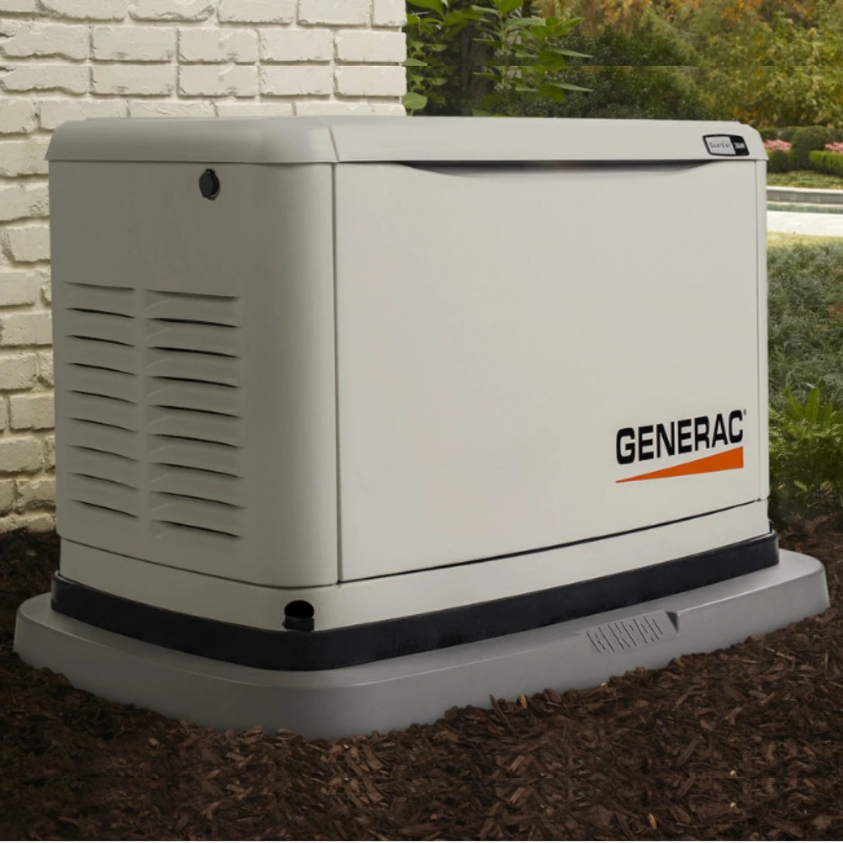 Actual application of GenPad on a Generac generator outdoors on a grassy area with a brick wall and greenery in the background