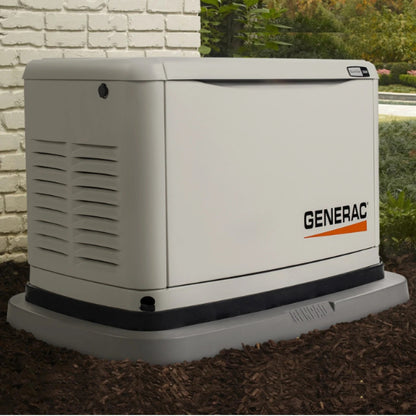 Actual application of GenPad on a Generac generator outdoors on a grassy area with a brick wall and greenery in the background