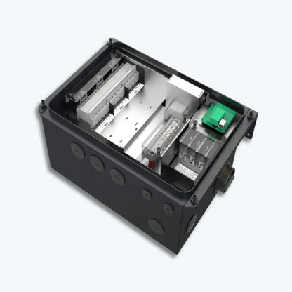 An industrial electrical control box with its top cover removed, showing internal components including terminal blocks, a metal heat sink, and a small green circuit board, set against a light gray background.